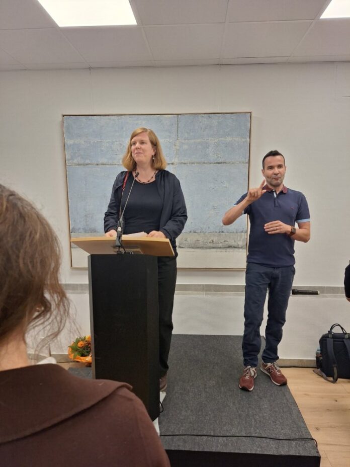 Eroeffnung-260826___Gesundheitskiosk_Ansprache-Frau-Stadtraetin-Milena-Loebcke-unterstuetzt-mit-Gebaerdensprache